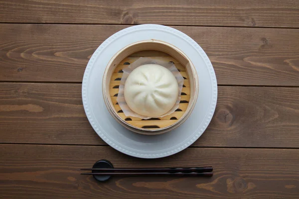 steamed meat bun baozi on wooden table