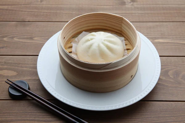 steamed meat bun baozi on wooden table