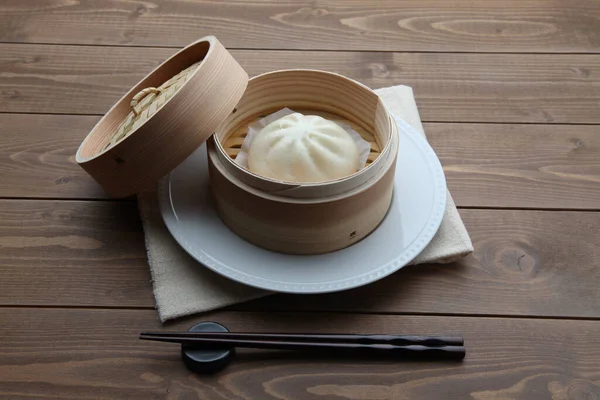 steamed meat bun baozi on wooden table