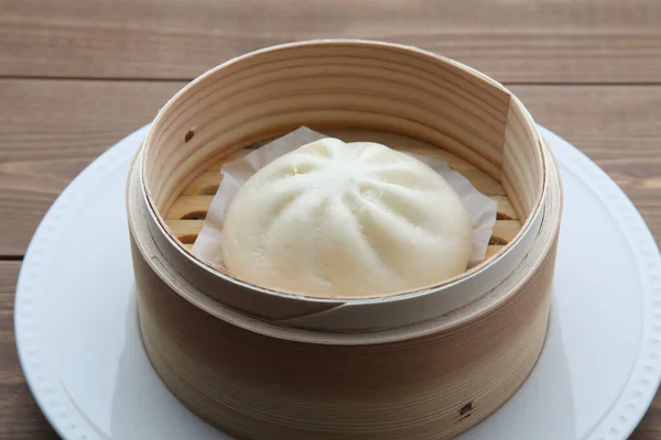 steamed meat bun baozi on wooden table