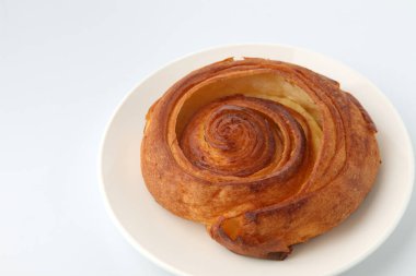 Beyaz arka planda izole edilmiş tabakta yuvarlak Danimarka ekmeği