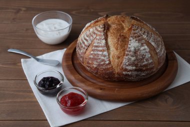 Acı de kampagne Fransız ekmeği ve ahşap masada çilek reçeli.