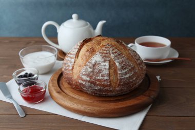 Acı de kampagne Fransız ekmeği ve ahşap masada çilek reçeli.