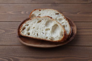 Dilimlenmiş Fransız ekmeği acı verici, ahşap masada izole edilmiş.