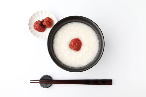Рисова каша з солоною маринованою сливою в мисці палички ізольовані на білому фоні — стокове фото