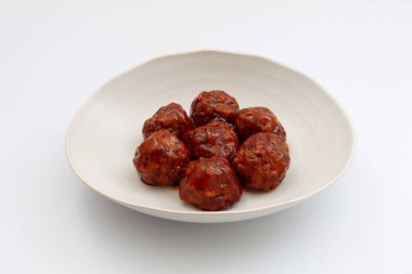 Beyaz arka planda tatlı ve ekşi soslu etli börek.