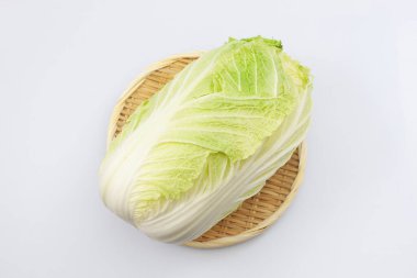 Beyaz arka planda bambu süzgeci üzerine Çin lahanası