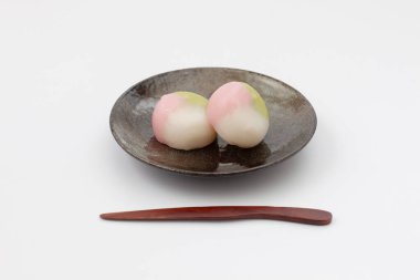 Beyaz arka planda üç renkli hamur tatlısı Japon pastası tabağı.