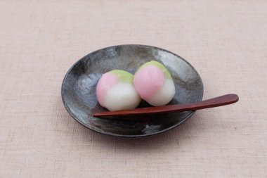 Masa örtüsü üzerinde üç renkli hamur tatlısı Japon pastası.