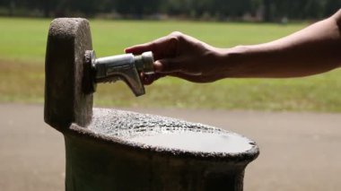 Biri çeşmeden su içiyor.