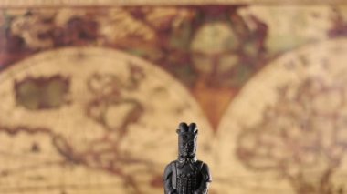 Çok eski bir dünya haritasındaki Terracotta savaşçı heykelinin yakınında.