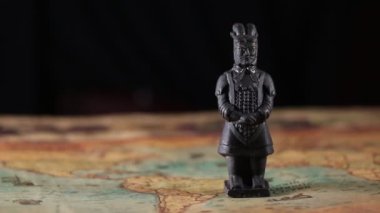 Çok eski bir dünya haritasındaki Terracotta savaşçı heykelinin yakınında.