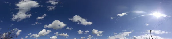 Panorama van de lucht. Luchtige wolken met de zon. — Stockfoto