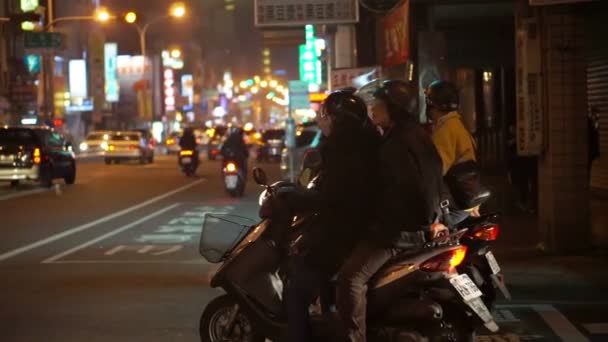 Tainan, Tayvan - Şubat, 2016: Tayvanlı motosiklet trafik lambasından gece pazarı için bekliyor. Motosiklet Tayvan en yaygın bir araçtır — Stok video