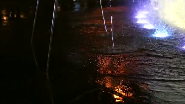 Barevné vodní fontána v noci. voda tekoucí textury světlo a barvu zblízka — Stock video