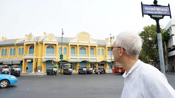 Senior asian guy vor klassischer thailändischer architektur an der na phra lan road in bangkok, thailand — Stockfoto