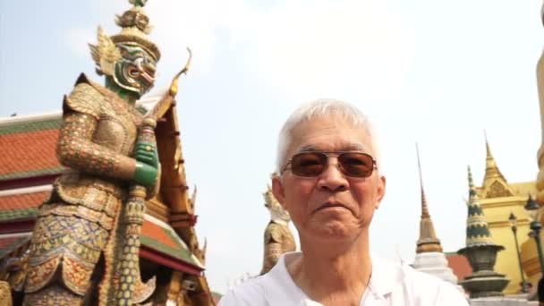 Asijské starší muž navštívit Wat Phra Kaew, chrám Emerald Buddha mezník v Bangkoku, Thajsko — Stock video