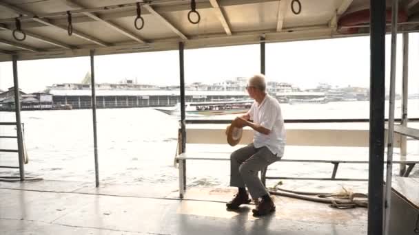 Homem asiático sênior montando um barco de balsa para atravessar o rio Chaopraya ao sol da manhã — Vídeo de Stock