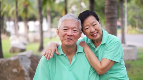 Счастливая старшая азиатская пара улыбается после тренировки в парке — стоковое видео