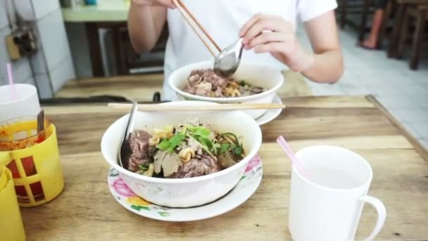 Vídeo Menina asiática comendo macarrão local no restaurante tailandês — Vídeo de Stock