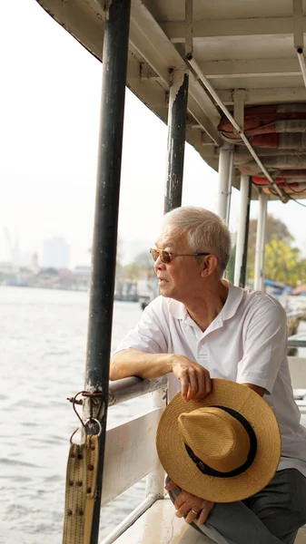 Senior Aziatische man rijden een veerboot naar het Kruis Chaopraya rivier ik — Stockfoto