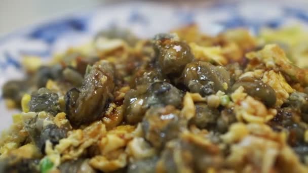 Ostras fritas y tortitas de huevo en un plato caliente. Taiwán debe comer plato de mariscos en el mercado nocturno — Vídeo de stock