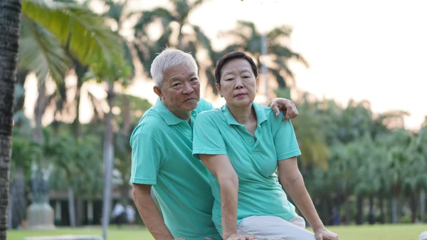 Lyckliga asiatiska senior paret leende efter träning i parken — Stockfoto