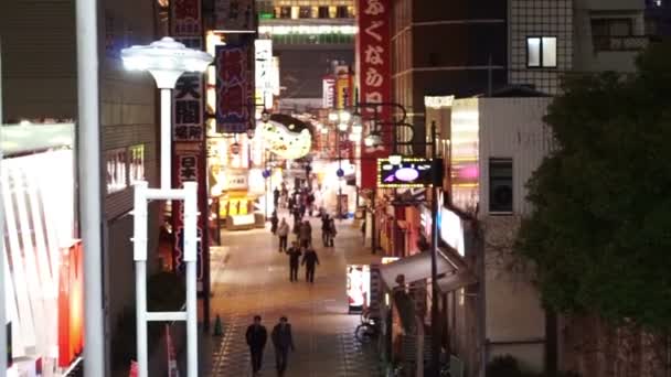 Osaka, Japán - március, 2015-re Tsutenkaku torony Shinsekai kerület bevásárló. Régi Street Osaka emberek séta és eszik étteremben éjszaka — Stock videók