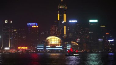 Hong Kong - Nisan 2016: Hong Kong gökdelenler. Gece kırmızı antik yelkenli tekne ile dünya ünlü manzarası