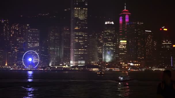 Hong Kong - April 2016: Wolkenkrabbers van Hong Kong. Wereld beroemde skyline in de nacht met rode oude zeilboot — Stockvideo