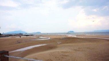 düşük tide Beach öğleden sonra. Savaş gemisi uzakta ile deniz kıyısı