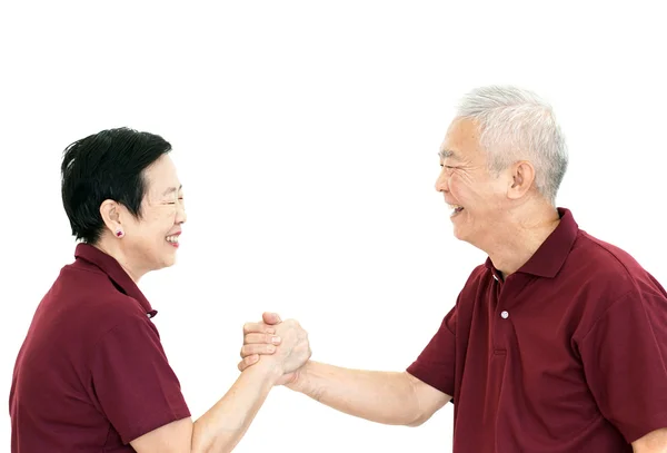 Счастливая азиатская старшая пара, держась за руки на белом изолированном фоне — стоковое фото