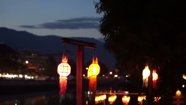 Thaise stijl Lanna vlag en papieren lantaarns ingericht door de rivier in Yee-peng festival, Chiangmai, Thailand — Stockvideo