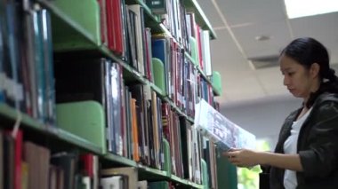Kadın, Asyalı kız öğrenci stand raflardan kitap okuma, arama