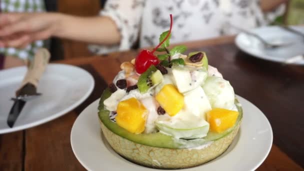 Deliciosa ensalada de frutas en un tazón de melón. Uvas recogidas, sandía, melón y aderezo para ensaladas alimentos saludables — Vídeo de stock