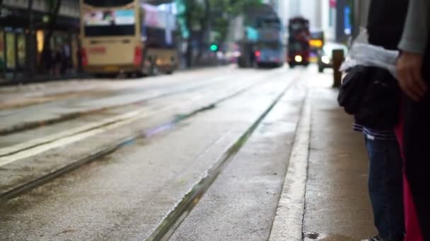 Iconico concetto di trasporto tram di Hong Kong. Persone in attesa alla stazione del tram con sfondo di auto si avvicina — Video Stock