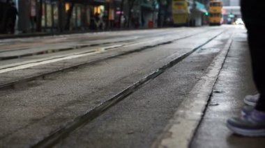 İkonik Hong Kong tramvay taşımacılığı kavramı. Araba yaklaşırken arka plan ile tramvay istasyonunda bekleyen insanlar