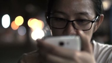 Asyalı kadınlar manifatura city gece açık renkli adlı ile akıllı telefon kullanarak camlı