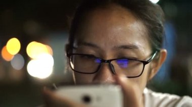 Asyalı kadınlar manifatura city gece açık renkli adlı ile akıllı telefon kullanarak camlı