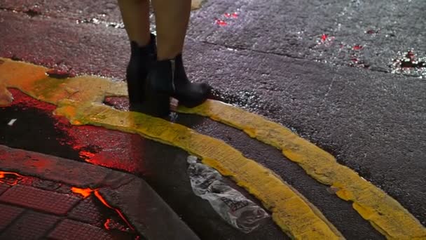 Pessoas que atravessam a rua molhada à noite. Cidade vida abstrata — Vídeo de Stock