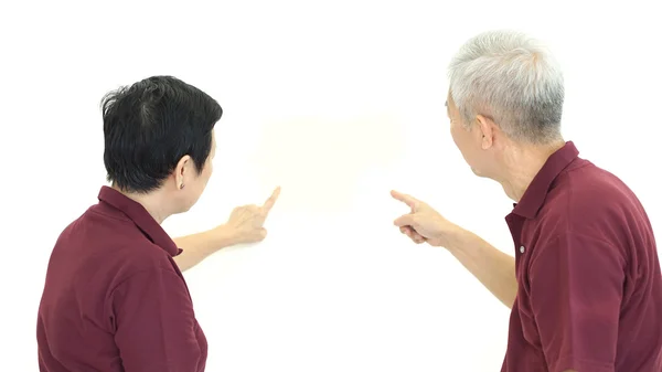Азиатская старшая пара, указывающая на белую изолированную спину — стоковое фото