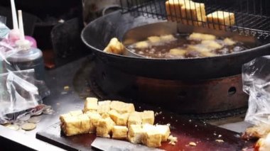 Adam kızarmış yağ tencerede stinky tofu. Tayvan'ın ünlü ve ikonik fermente soya peyniri