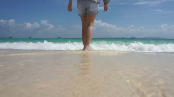 Asian girl walking down the sea with water hitting camera scene — Stock Video