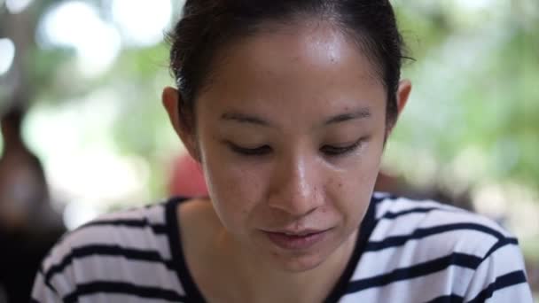 Азиатская девушка смешанной расы смотрит в камеру с улыбкой на лице — стоковое видео