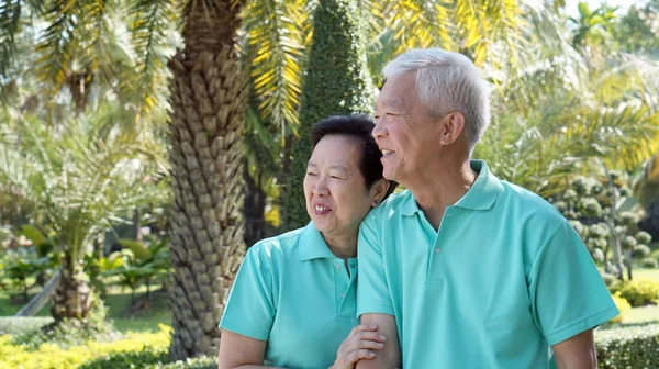 Asiatische Senioren Paar lächelnd zusammen in der grünen Natur Hintergrund — Stockfoto