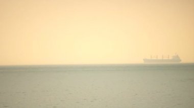 Yelken, Puslu deniz okyanus ufuk altın gökyüzünde saatte kargo kargo gemisi