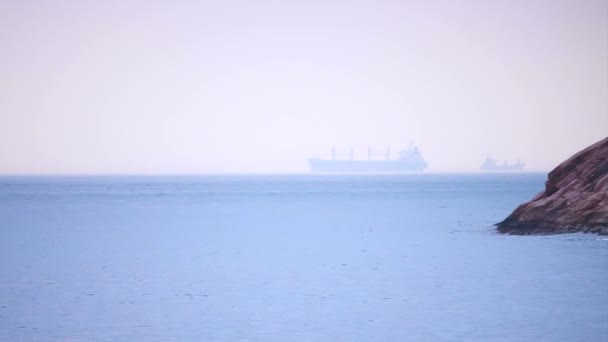 Cargo freighter ship sailing, moving at ocean horizon sky in hazy sea — Stock Video