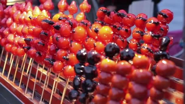 Карамельные помидоры, сахарные глазурованные фрукты и овощи продаются на палочке в Тайбэе. Тайваньский ночной рынок — стоковое видео