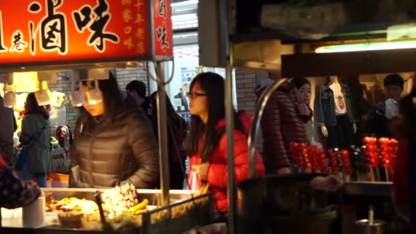 Taipei, Taiwan: February 2016: People buying food in front of vendor stalls around Shilin night market — Stock Video