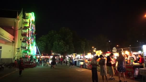 Chiangmai, Thaiföld - November 2015-ig: Éjszakai templom piaci Loi krattong fesztiválon. Sok az utcai élelmiszer-szállító standokon, a játék és a ferris kerék. Helyi és turista élvezi éjszakai látnivalók — Stock videók